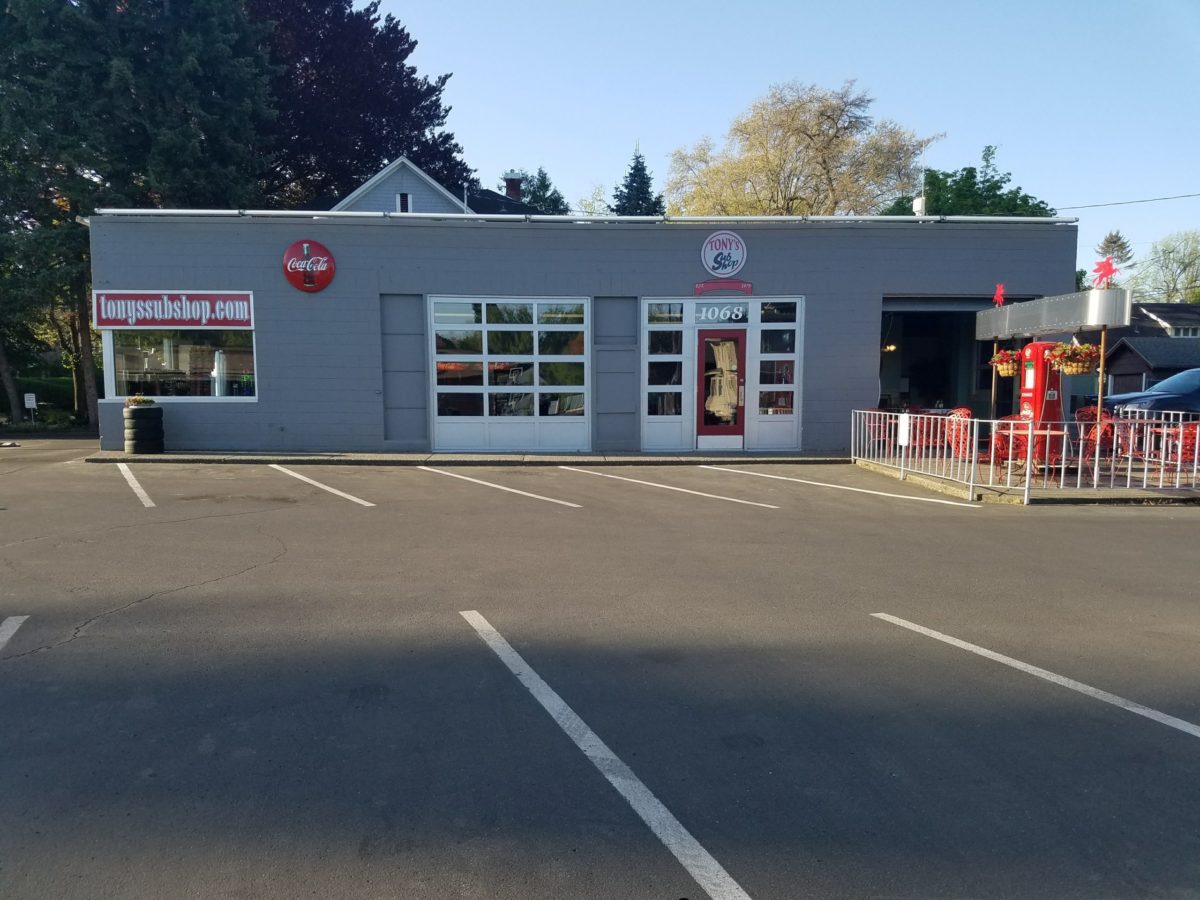 Tony's Sub Shop storefront on E Isaacs Ave, the converted gas station with patio and red vintage gas pump